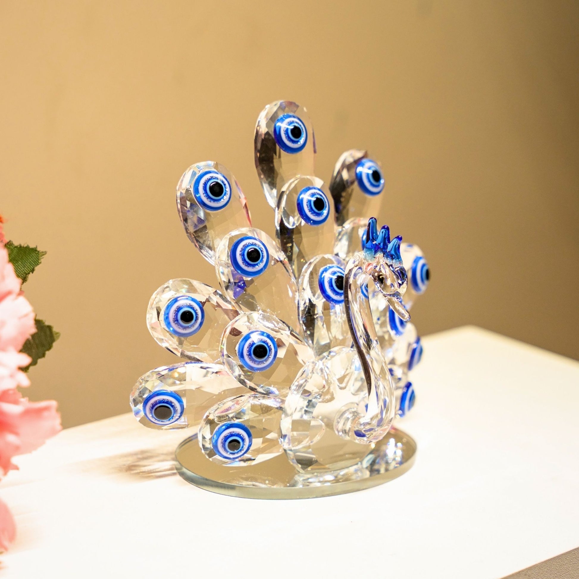 Crystal peacock figurine with blue eyes on a beige background